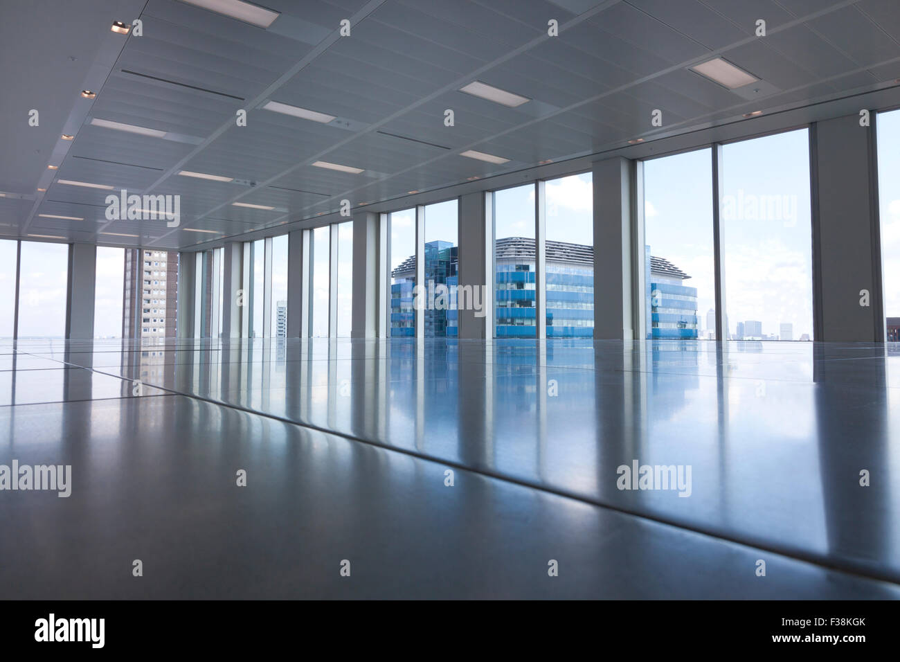 Leeres moderne Bürozimmer mit großen Fenstern und Reflexionen auf dem Boden Stockfoto