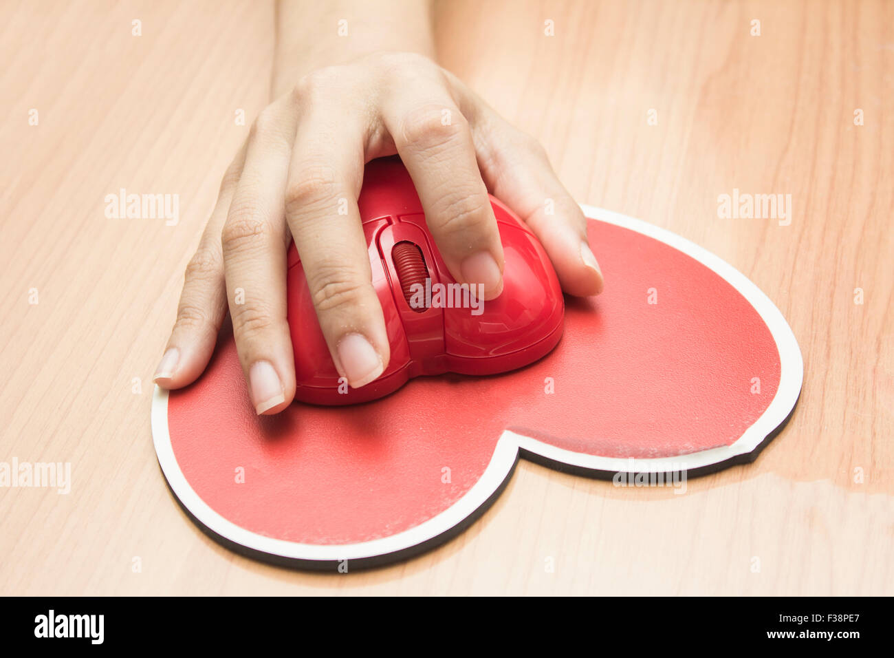 Weibliche Hand mit Computer-Maus am table.valentine Tag Stockfoto