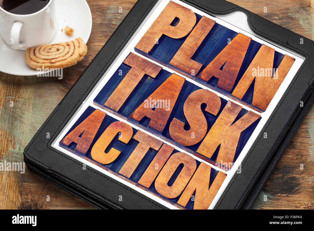 Plan, Aufgabe, Aktion Wort Abstract - Text in Vintage Buchdruck Holzart auf einem digitalen Tablet mit einer Tasse Kaffee, management Stockfoto