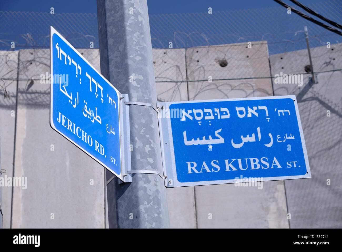 Straßenschilder in hebräischer Sprache und arabischer Sprache neben der massiven Trennmauer, die Israel in Abu Dis oder Abu Deis, einer palästinensischen Gemeinde, errichtet hat und zum palästinensischen Gouvernement Jerusalem südöstlich von Jerusalem in Israel gehört Stockfoto
