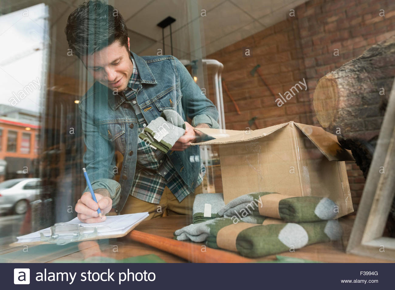Arbeiter, die Verarbeitung neuen Inventars in Zwischenablage im shop Stockfoto