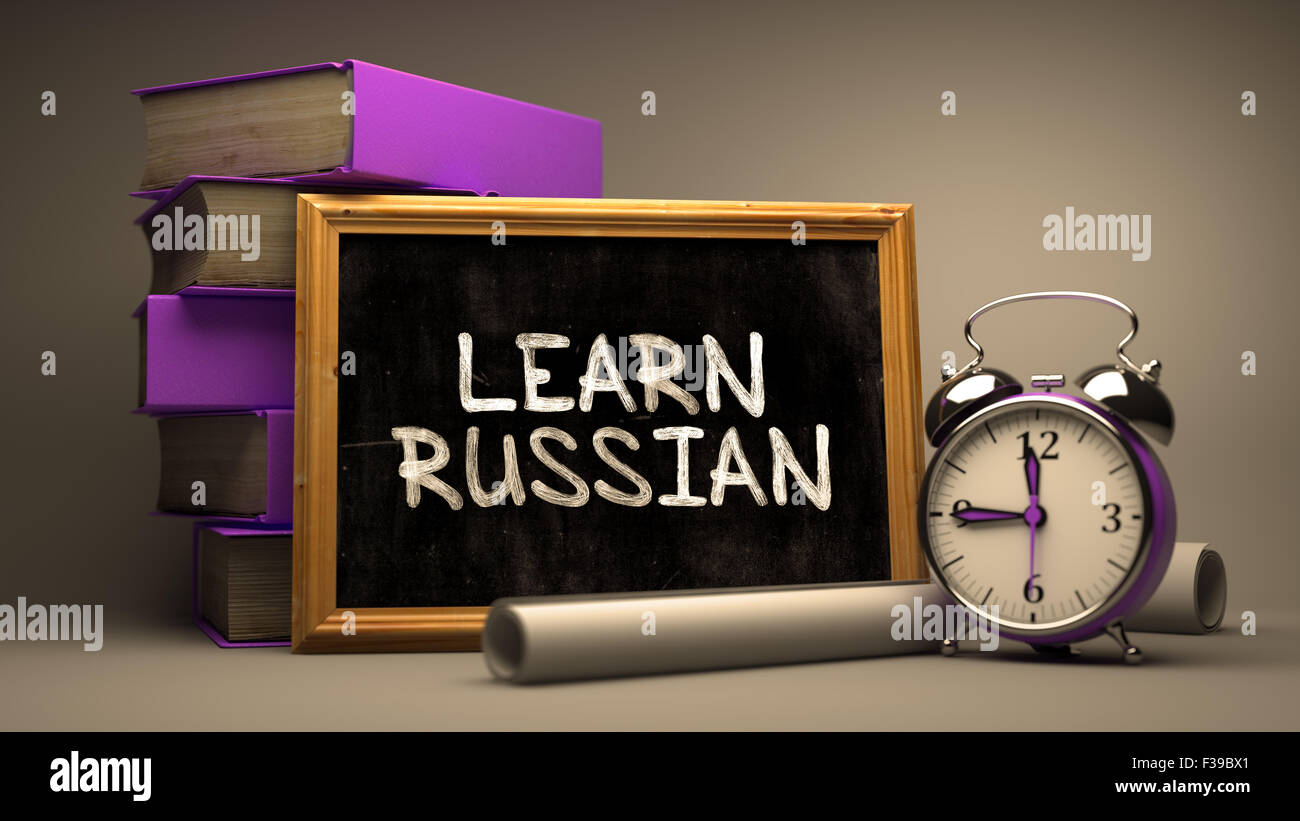Motivierenden Zitat - lernen Sie Russisch - Tafel mit handgezeichneten Text, Stapel Bücher, Wecker und Papierrollen auf unscharfen Stockfoto