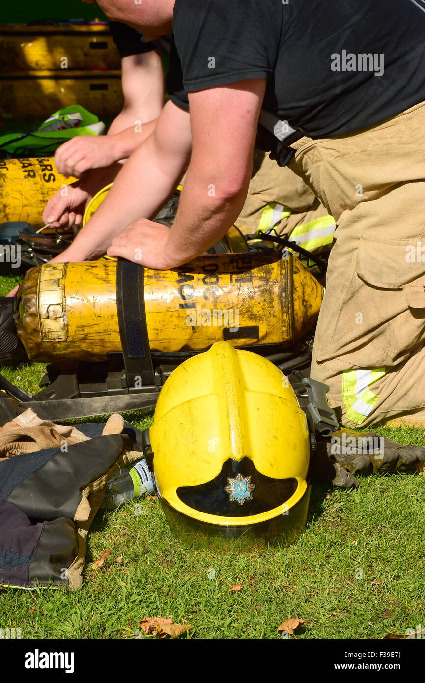 Feuerwehrleute bereiten Atemschutzgerät am Tatort eines Feuers. Stockfoto