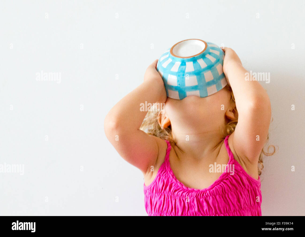 Mädchen mit dem Kopf zurück hält Getreideschale an ihren Mund Stockfoto