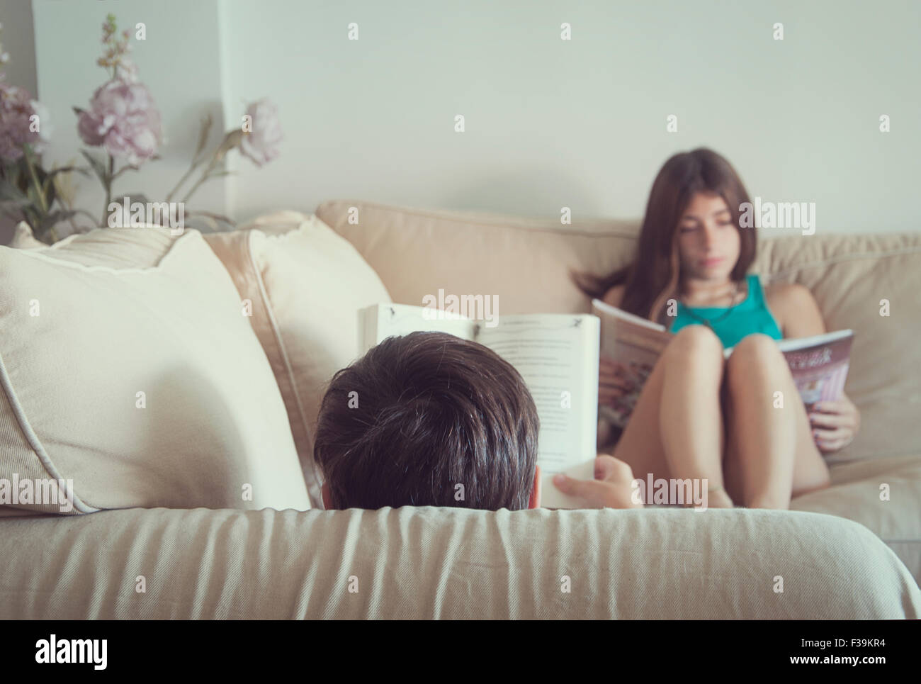 Teenager-Jungen und Mädchen sitzen auf dem Sofa, die Bücher zu lesen Stockfoto