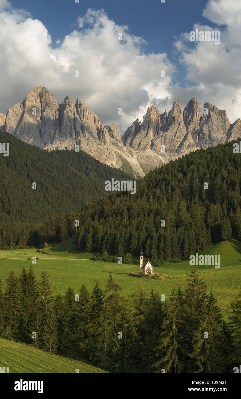 St. Johann Church (San Giovanni) in einem Tal mit Bergen im Hintergrund, Dolomiten, Südtirol, Italien Stockfoto