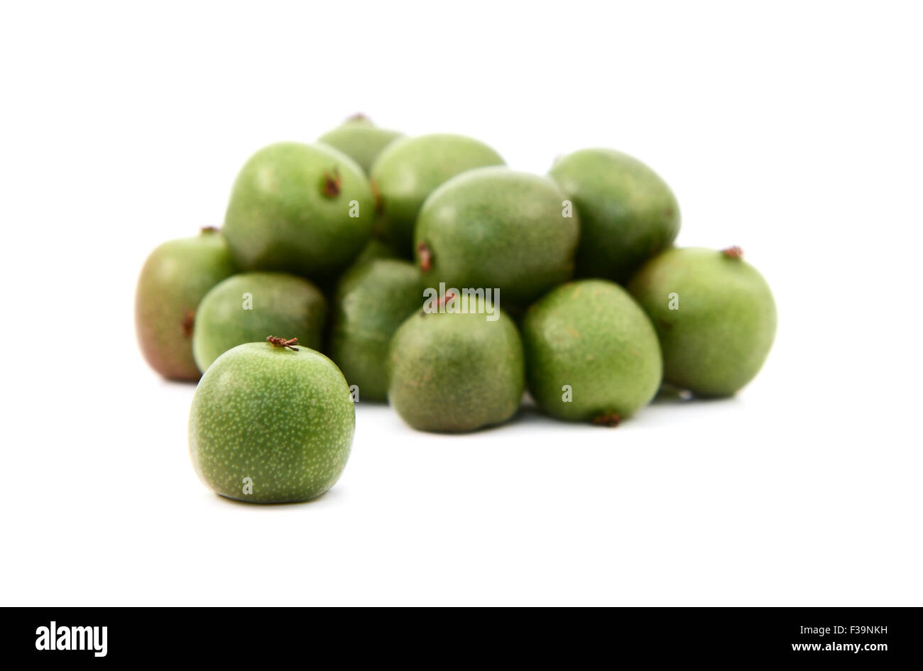 Kiwi-Beere in selektiven Fokus gegen Haufen von grünen Beeren, isoliert auf weißem Hintergrund Stockfoto