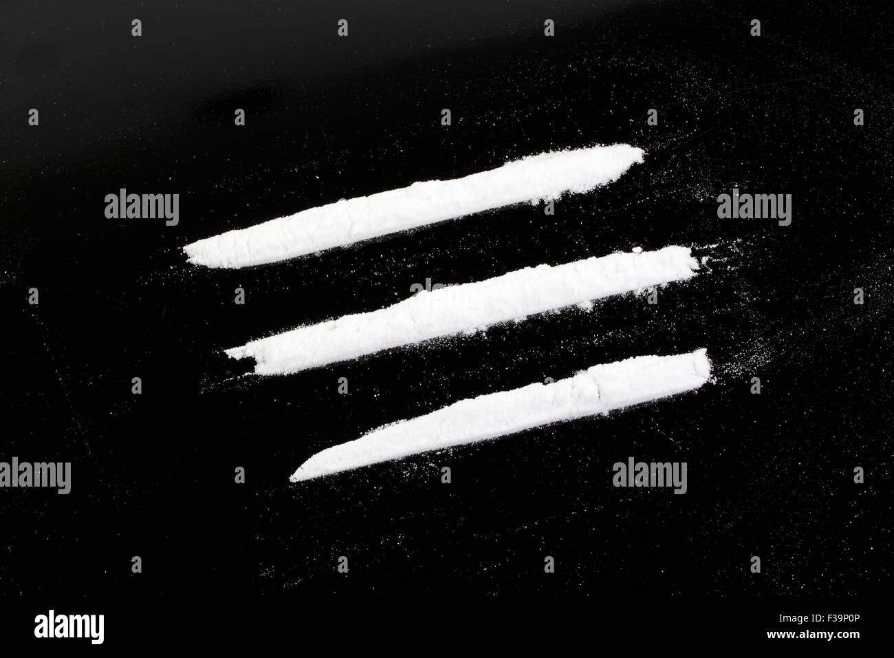 Kokainpulver in drei Linien auf schwarzem Hintergrund Stockfoto