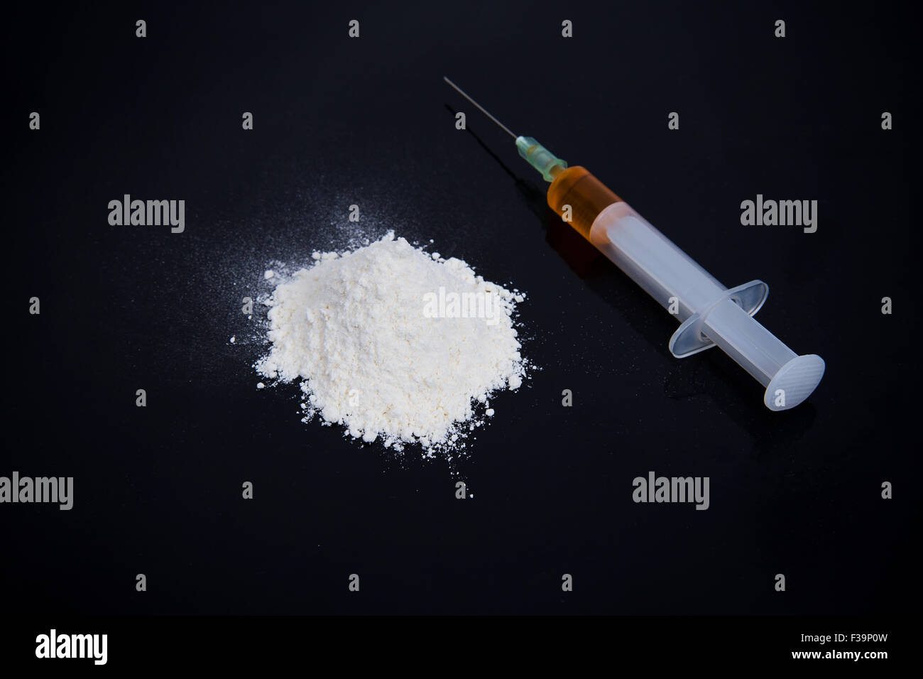Kokain Drogen Heap mit Spritze auf schwarzem Hintergrund Stockfoto