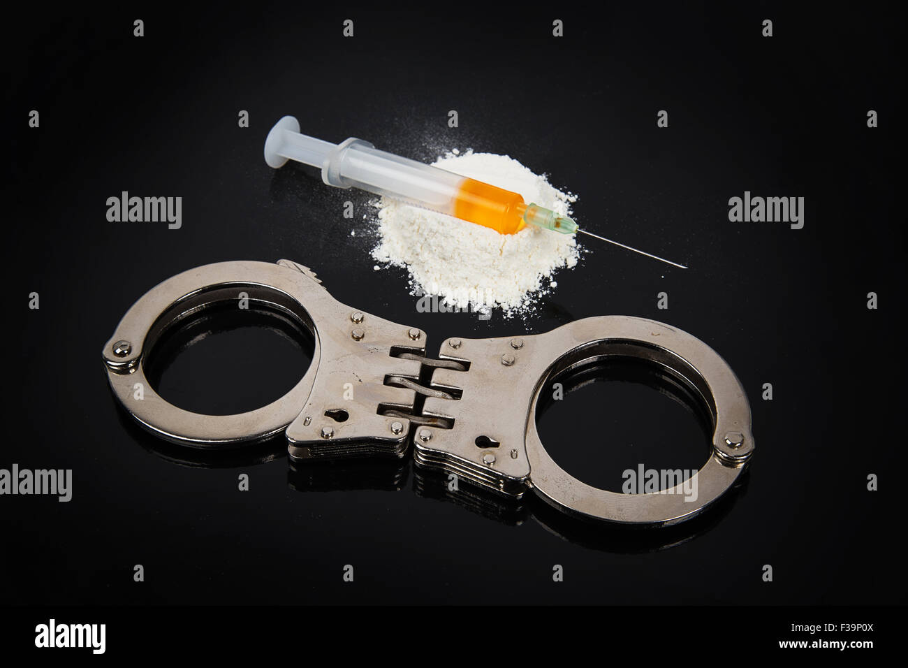 Kokain Drogen Heap mit Spritze und Handschellen auf schwarzem Hintergrund Stockfoto