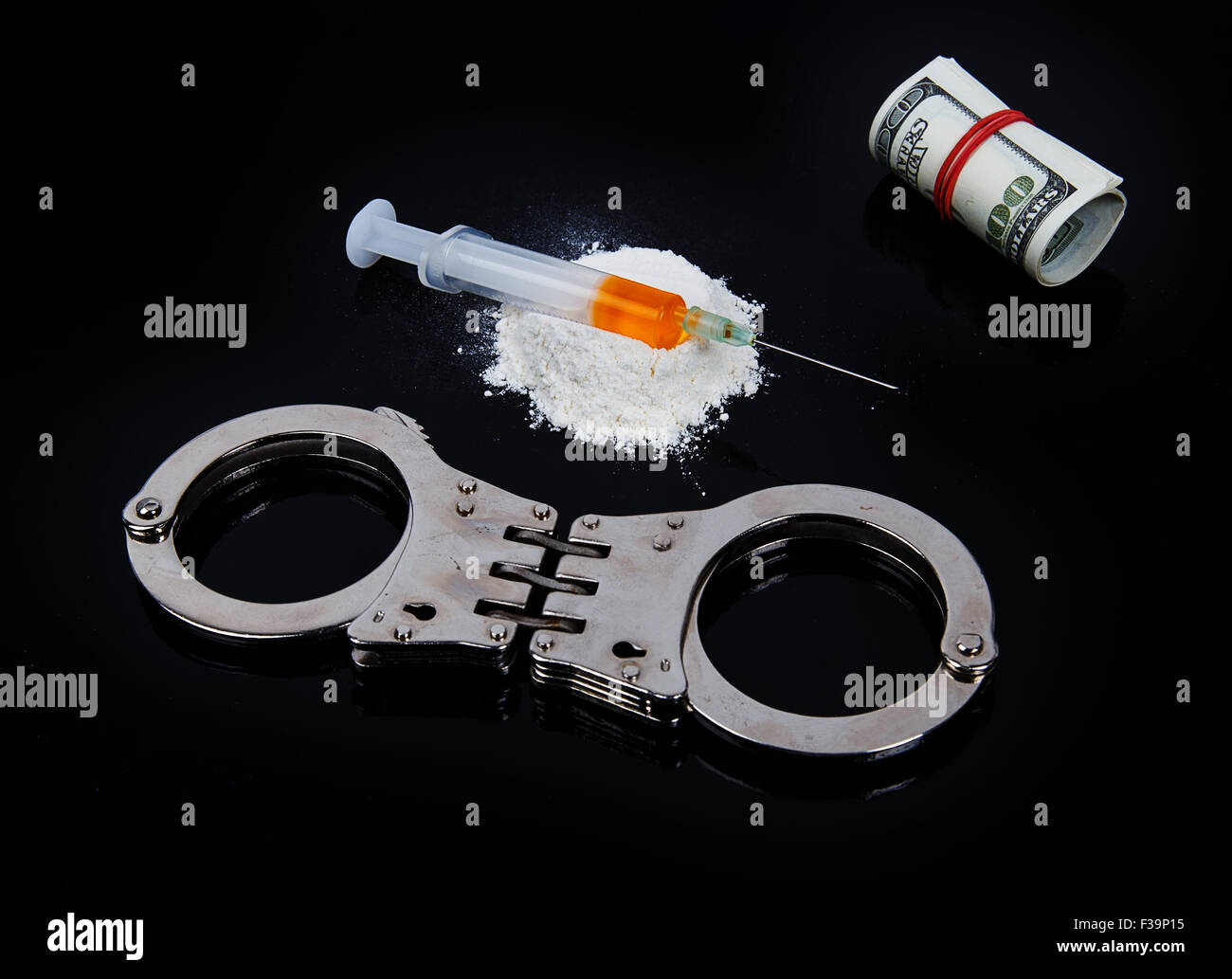 Kokain Drogen Heap mit Spritze und Handschellen auf schwarzem Hintergrund Stockfoto