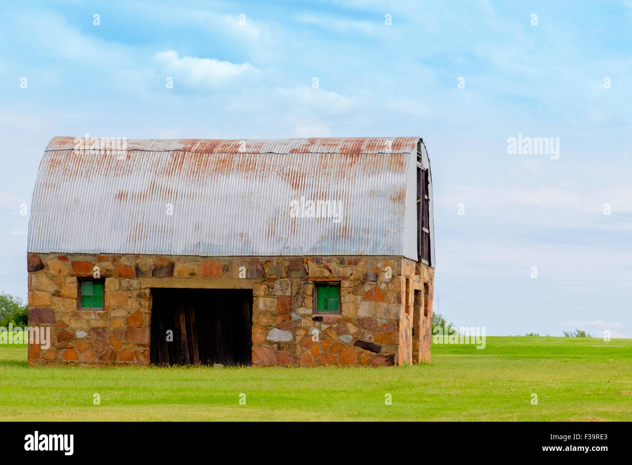 Eine Scheune mit einem rostigen Blechdach in Oklahoma, USA-Landschaft. Stockfoto