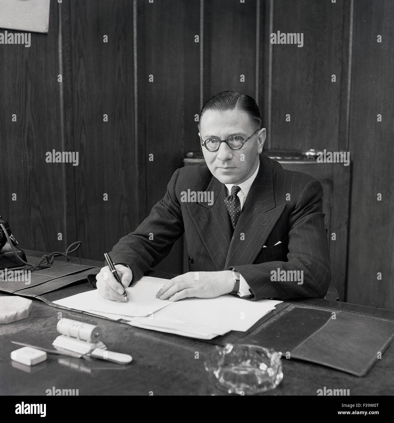 Historische, 1950er Jahre, Managing Director von der britischen jemals bereit elektrische Firma (GEREK) in seinem Büro einen Brief seine Unterschrift gesetzt. Stockfoto
