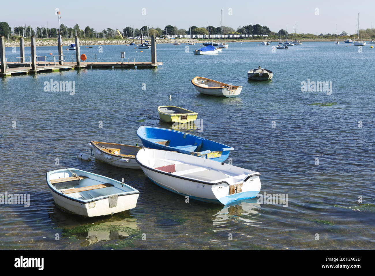Sammlung von kleinen Booten oder Ausschreibungen in Chichester Hafen von Emsworth. Boote bilden eine informelle Zeile vorne links nach hinten rechts. Stockfoto