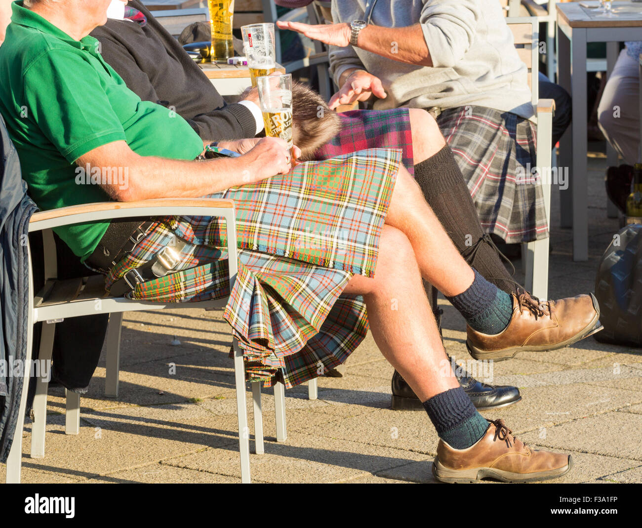 Schottische Männer tragen Kilts genießen Sie ein Bier außerhalb Pub. Stockfoto