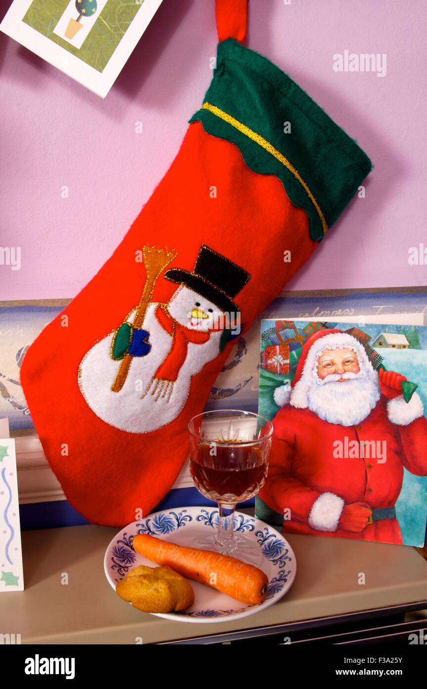 Nacht vor Weihnachten: Weihnachts-Strumpf hängt an einer Karotte für Rudolf und einen Sherry für Santa Stockfoto