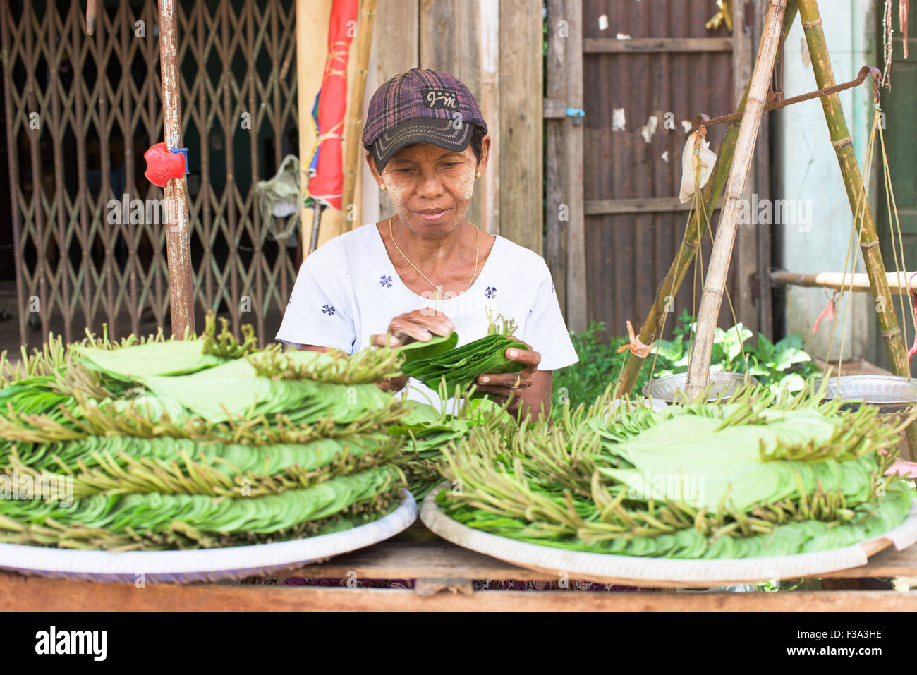 Frau verkaufen Betel Blätter, eine mld-Stimulans, die der Benutzer verlässt mit Blackis rote Zähne auf einem Markt in Myaungmya, Myanmar Stockfoto