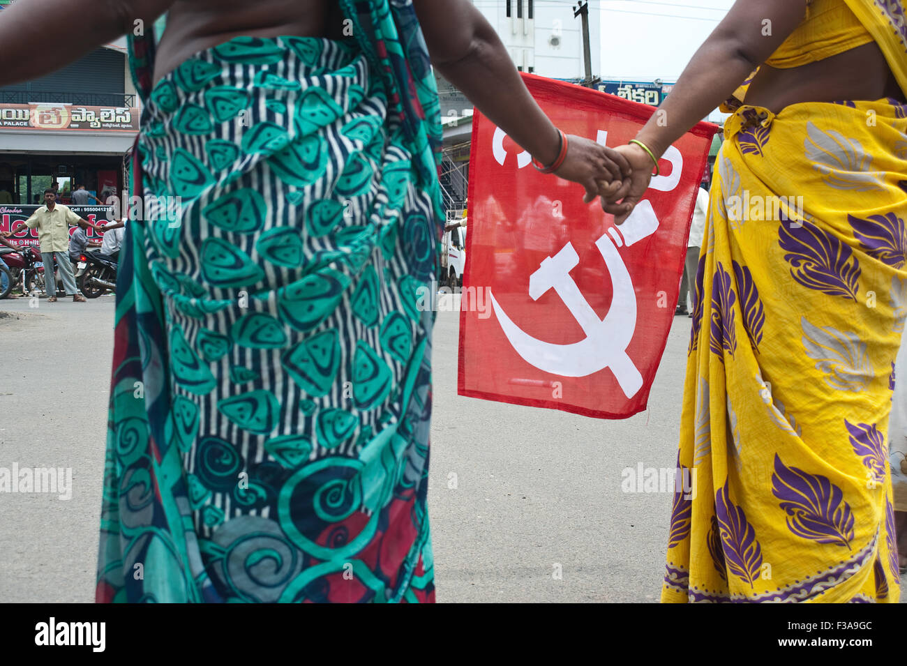 Städtische Arbeiter streiken. Eine Frau hält eine Fahne mit dem kommunistischen Logo (Indien) Stockfoto