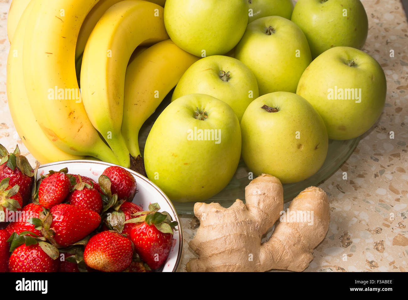 Stillleben mit Bananen, Äpfel, Erdbeeren und Ingwer. Stockfoto