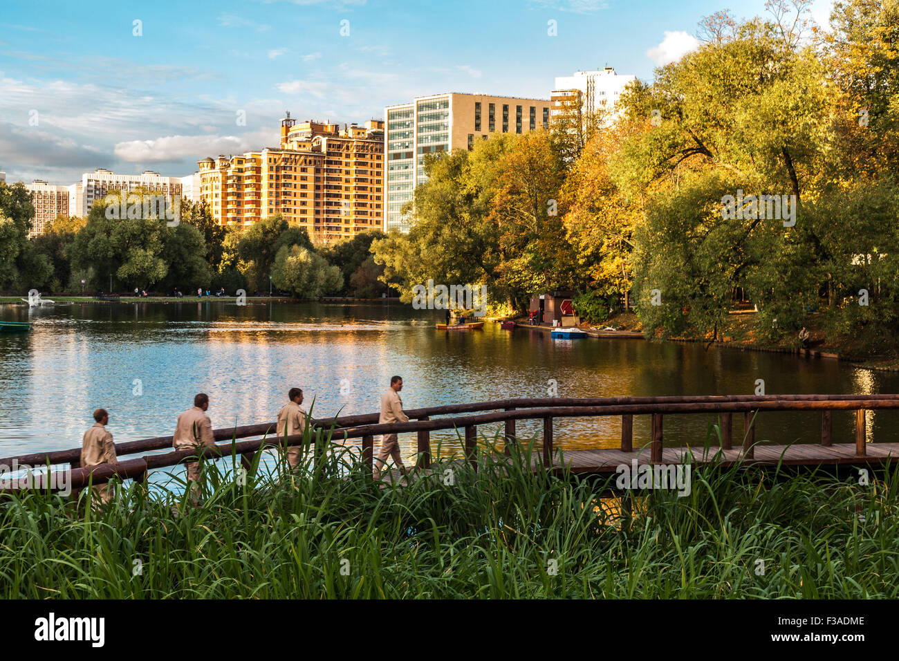 Woronzowski Park in Moskau. Auf der Holzbrücke gibt es vier Personen in leichter Kleidung. Stockfoto