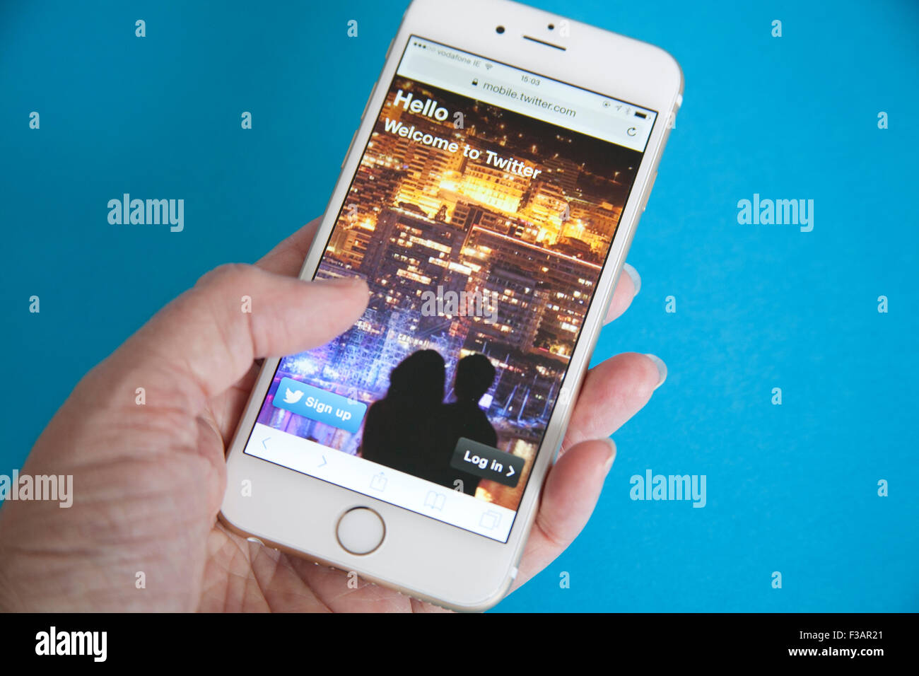 Gold und weiße Apple iPhone 6 mit Twitter anmelden Bildschirm vor einem blauen Hintergrund Stockfoto
