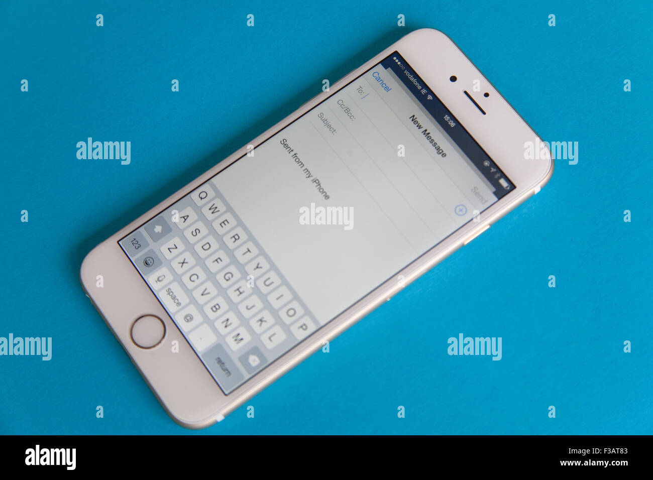 Senden einer e-Mail auf eine goldene und weiße Apple iPhone 6 auf blauem Grund Stockfoto