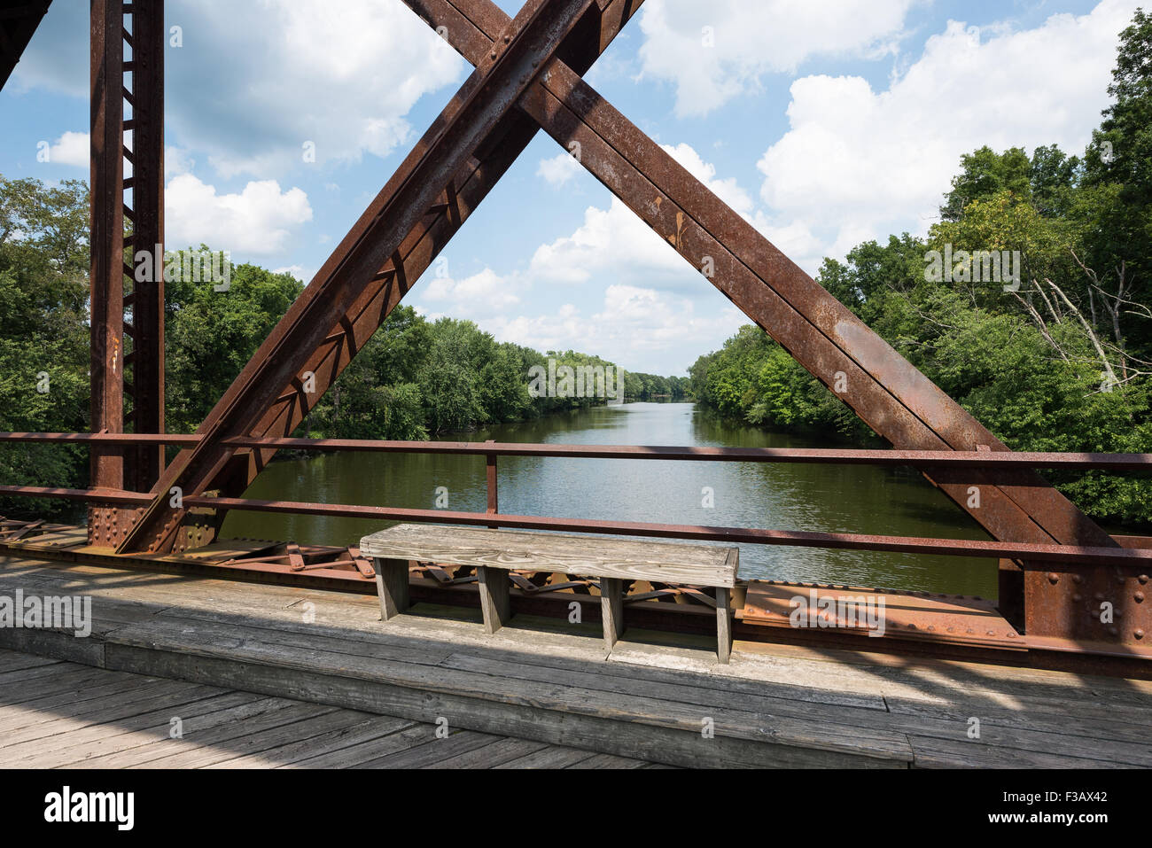 Sitzbank auf der wallkill River Rail Trail Bridge in den Catskills, New York mit Blick auf den Fluss durch die Brücke Struktur. Stockfoto