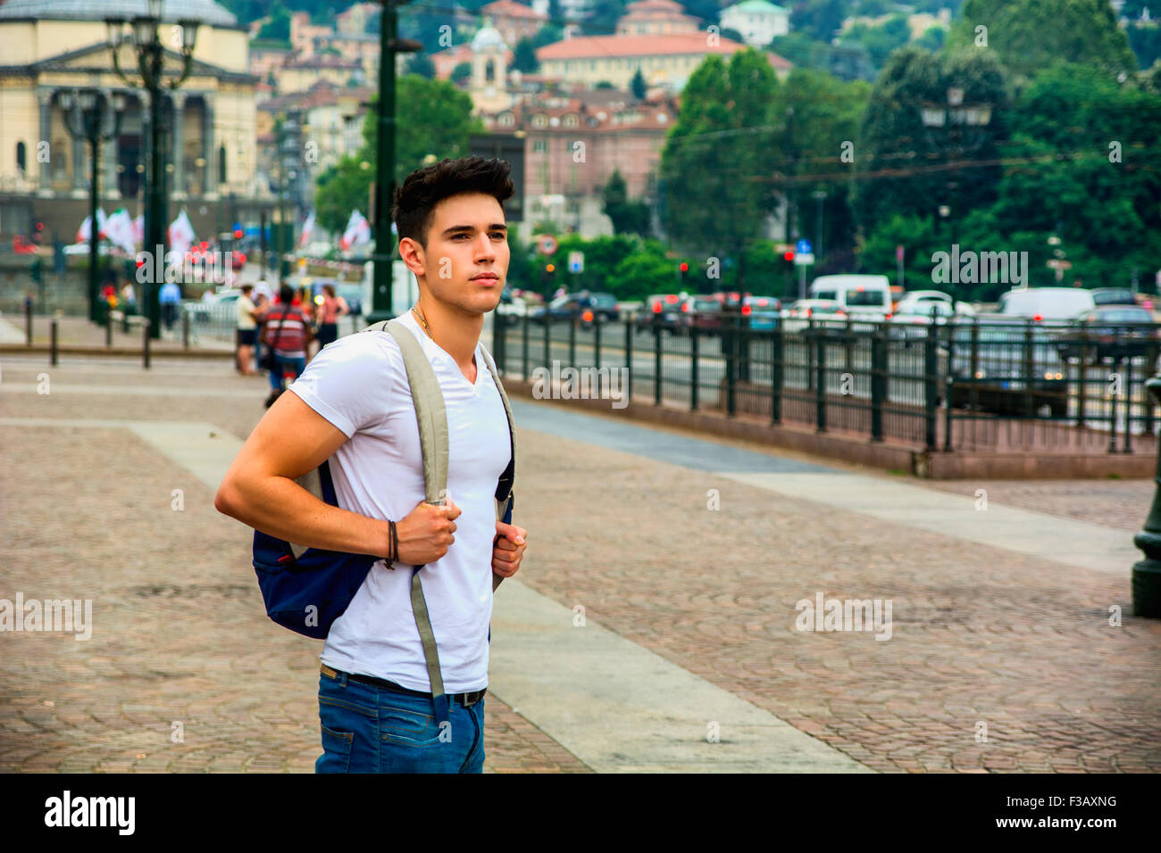 Hübscher junger Mann zu Fuß auf europäischen Stadtplatz, Piazza Vittorio Veneto in Turin, Italien Stockfoto