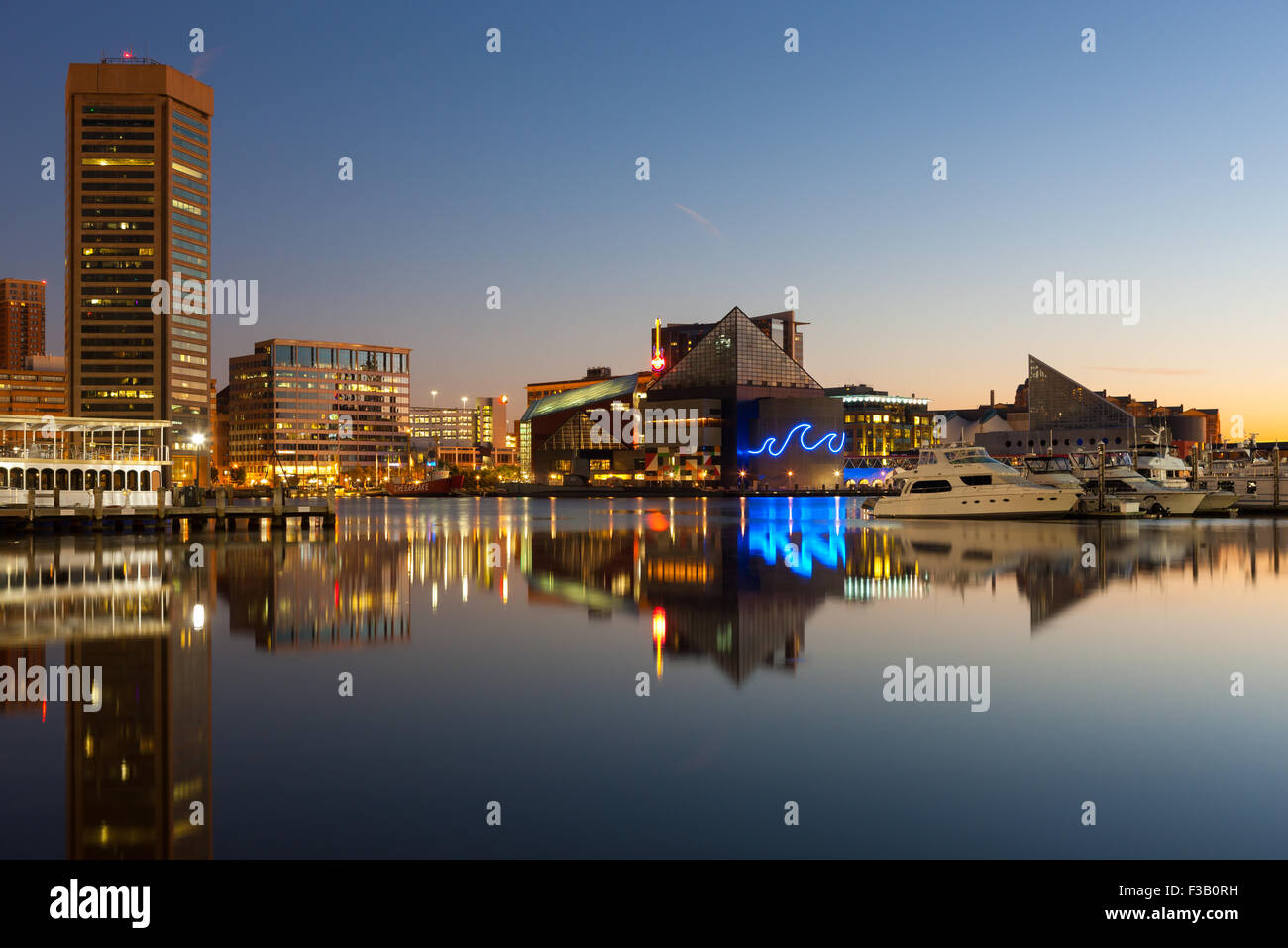 Skyline von Baltimore in der Morgendämmerung, einschließlich des World Trade Center und National Aquarium, spiegelt sich in den Gewässern der Innenhafen. Stockfoto