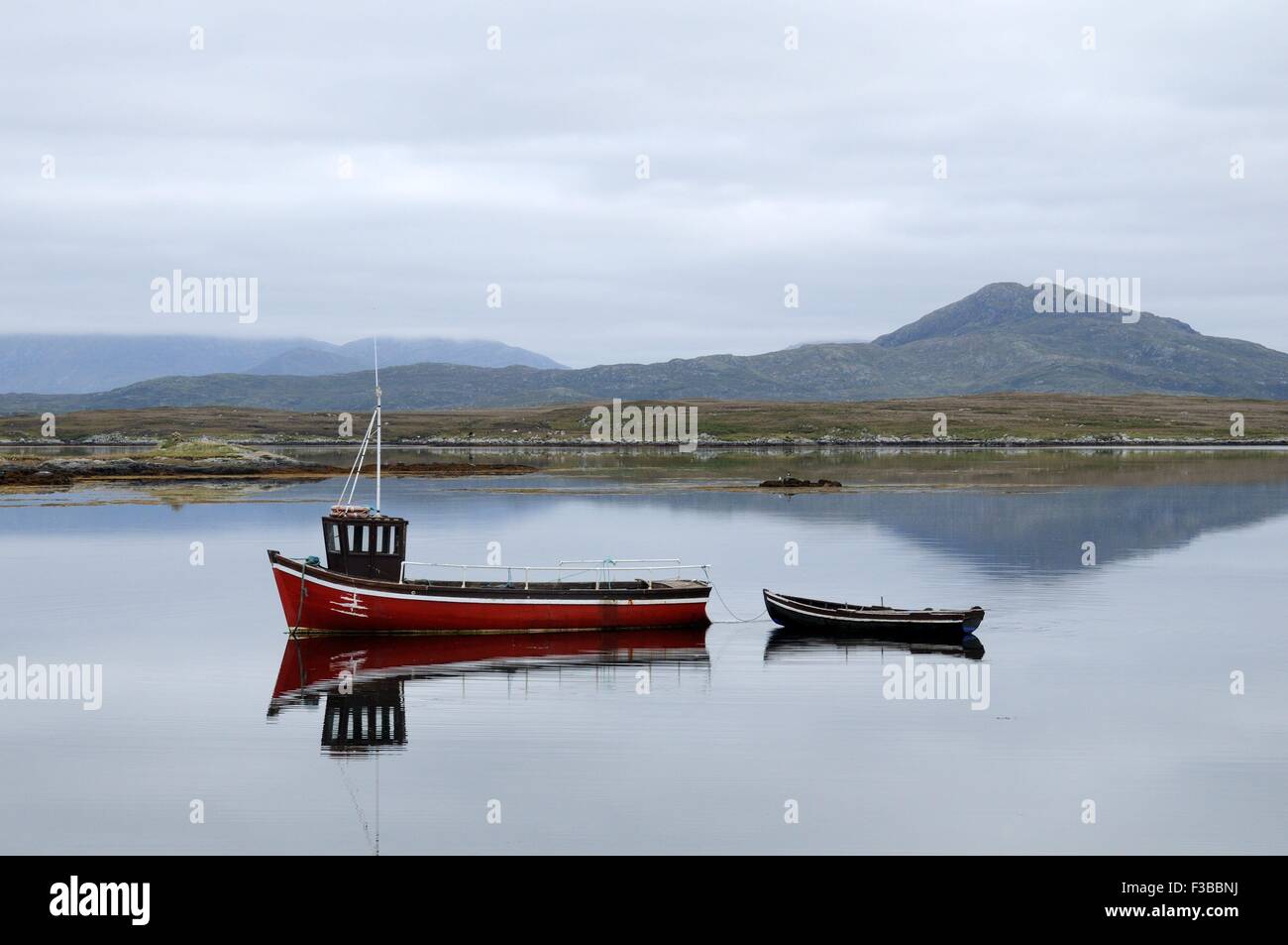 Roten Fischerboot spiegelt sich im frühen Morgenlicht Inishnee Roundstone Connemara County Galway, Irland Stockfoto