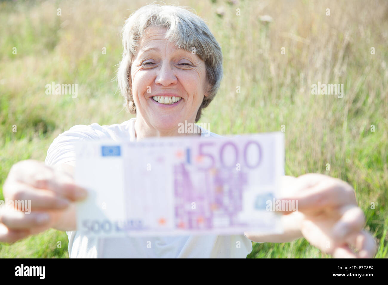 Alter Frau mit fünfhundert-Euro-Schein Stockfoto