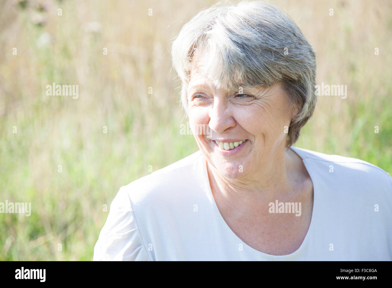 Alter Frau lächelnd weiße Wesen außerhalb Stockfoto