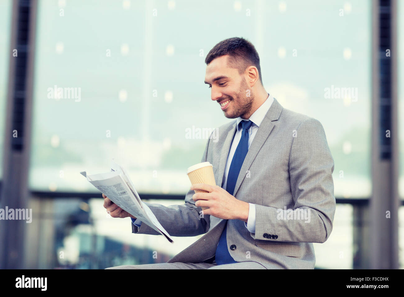 junger Geschäftsmann mit Kaffee und Zeitung Stockfoto