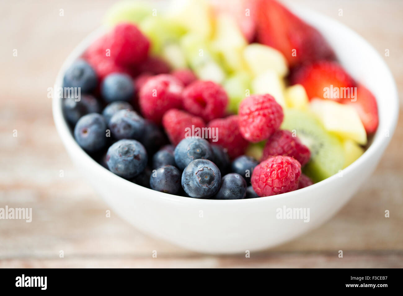 Nahaufnahme von Früchten und Beeren in Schüssel auf Tisch Stockfoto