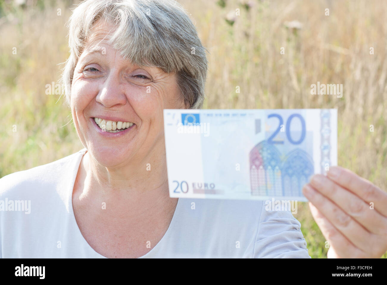 Ältere Frau, die 20-Euro-Schein Stockfoto