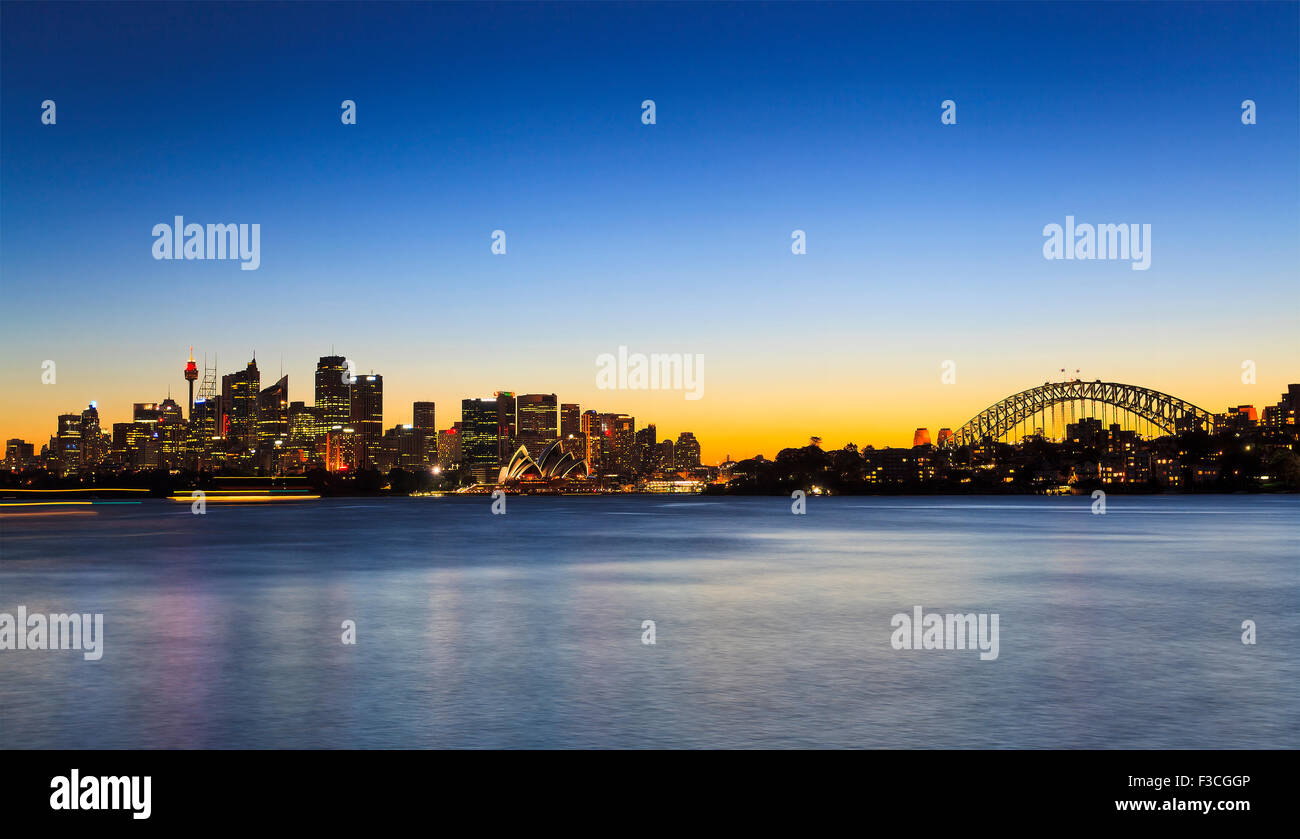 Sydney Panorama Cityline von CBD, Harbour Bridge bei Sonnenuntergang von Cremorne Point über verschwommenes ruhigen Hafen Wasser mit illumin Stockfoto