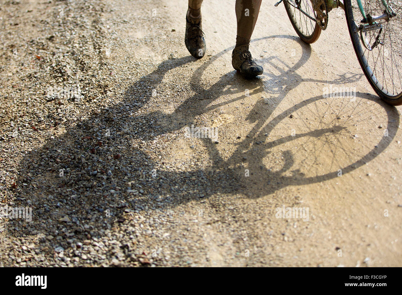 Toskana, Italien. 4. Oktober 2015. Der Schatten eines Radfahrers ist während der "Eroica" Radsport-Event für alte Fahrräder in das Chianti-Gebiet der Toskana, Italien, am 4. Oktober 2015 auf der Schotterstraße sehen. Mehr als 6.000 Radfahrer aus 66 Ländern tragen Vintage Radtrikots, Vintage Fahrrad gebaut 1987 oder früher, nahmen an der "Eroica'(heroic)-Radsport-Event durch die"Strade Bianche", die Schotterpisten des Chianti-Gebietes der Toskana. © Jin Yu/Xinhua/Alamy Live-Nachrichten Stockfoto