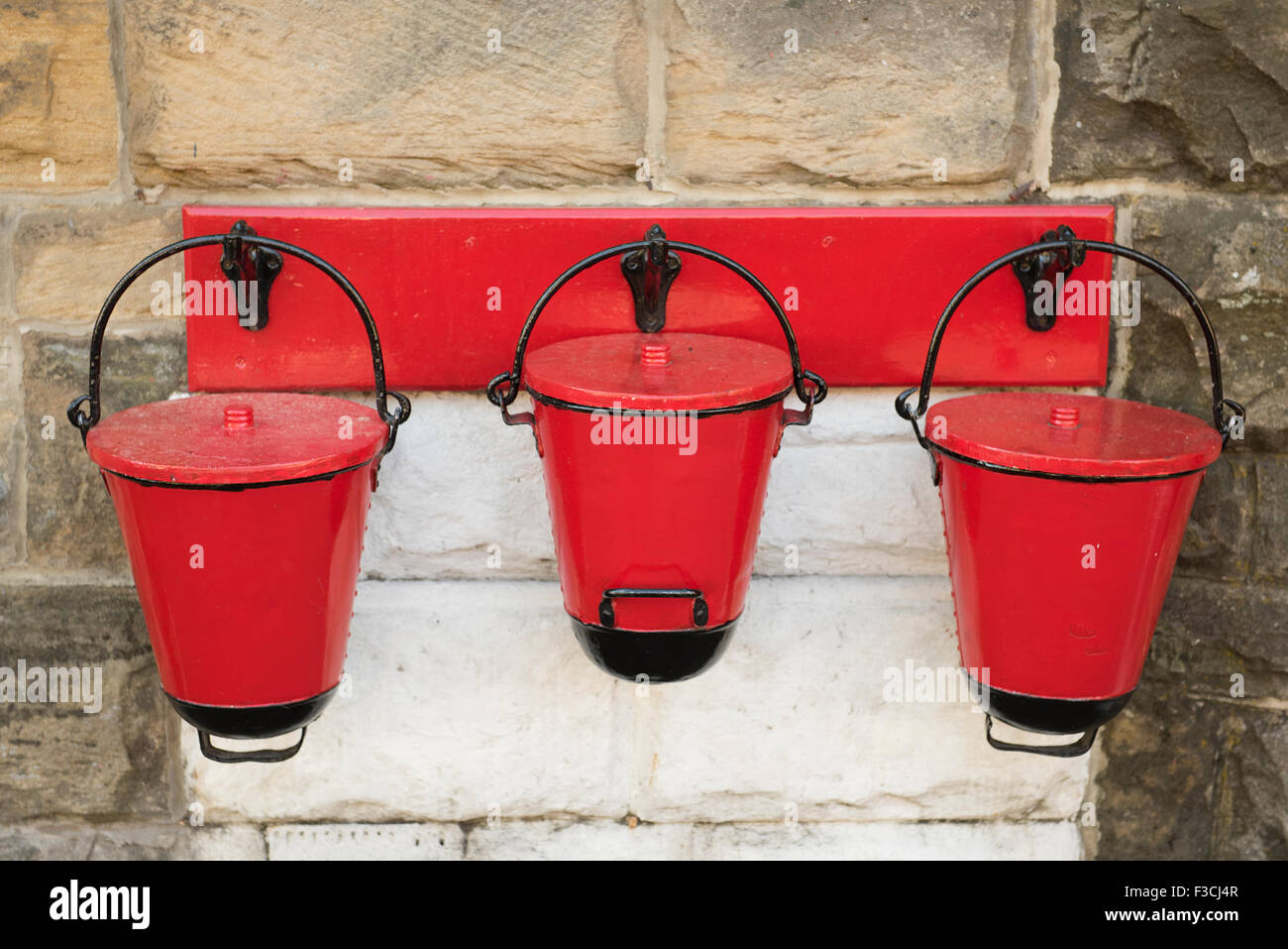 Drei rote Feuer Eimer hängen diese an Goathland Station auf der North Yorkshire Moors Railway. Stockfoto