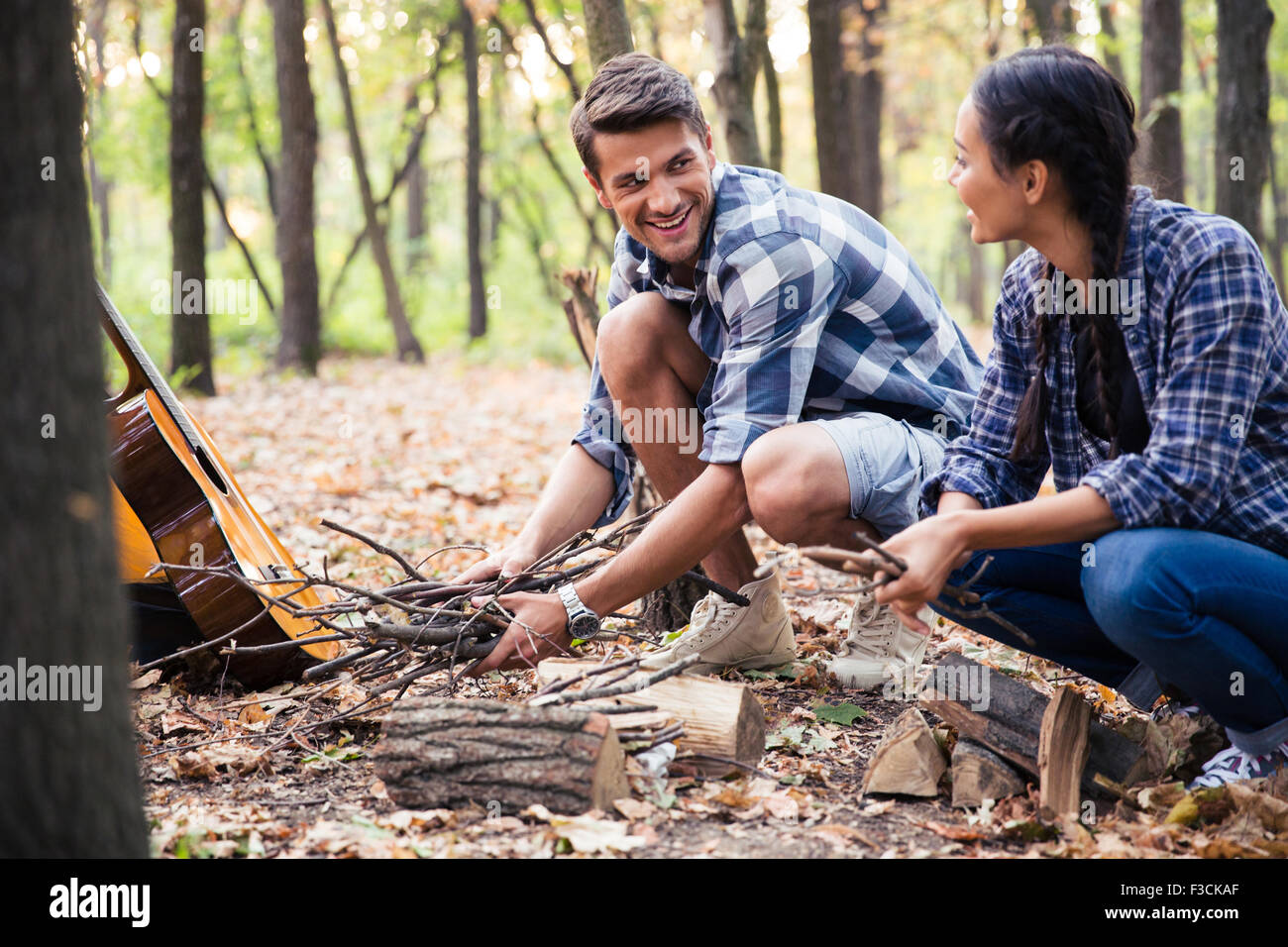 Porträt von ein paar Lesung für Lagerfeuer im Wald Stockfoto