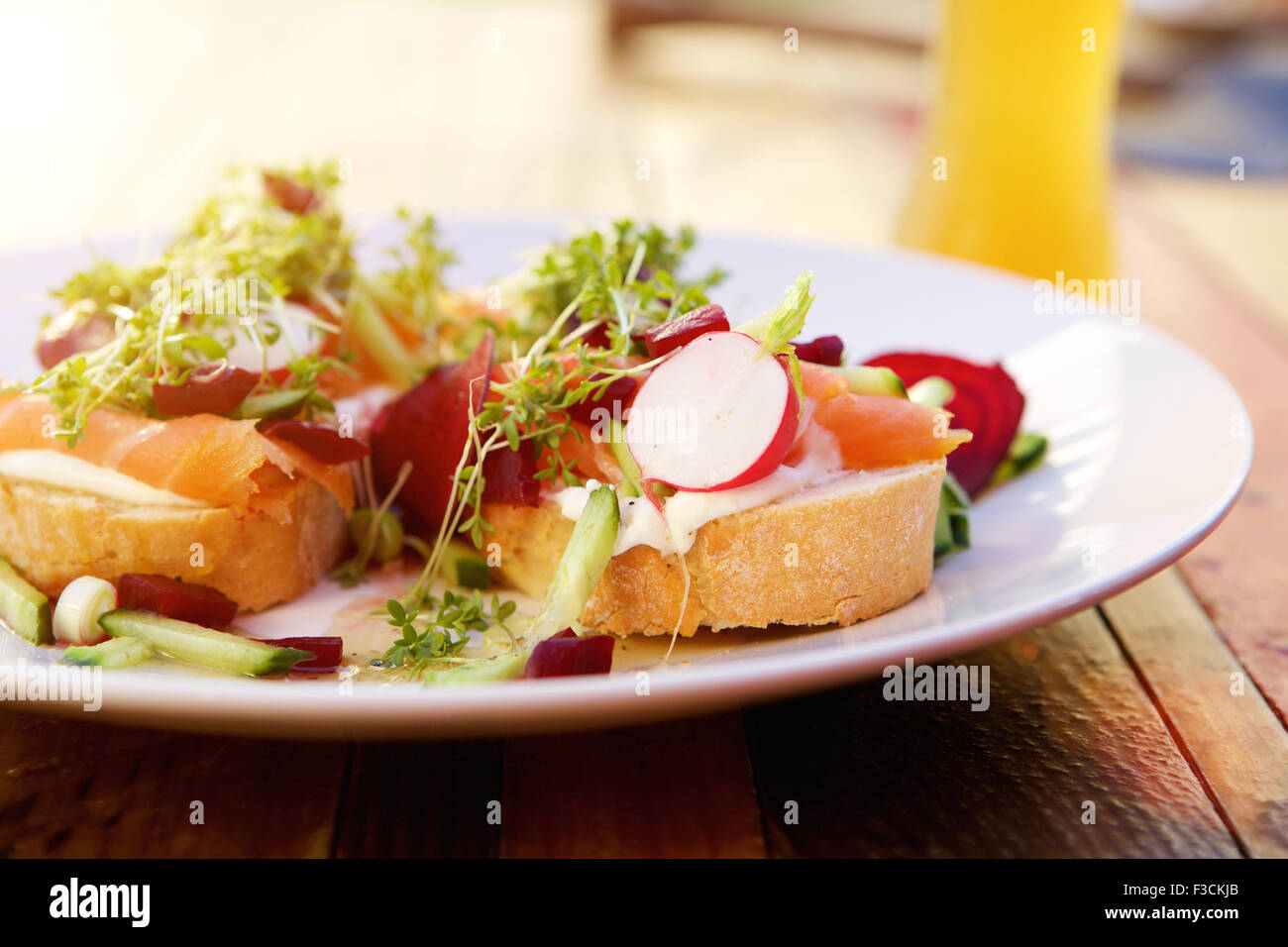 Frischer Salat mit geräuchertem Lachs Rettich und Rüben draußen auf einem Holztisch hautnah Stockfoto