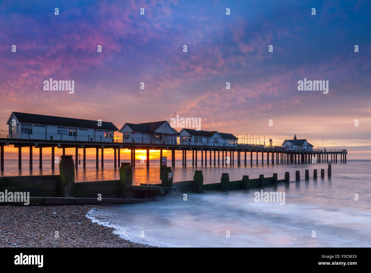 Die Sonne geht hinter dem Pier in Southwold in Suffolk in Mitte August. Stockfoto