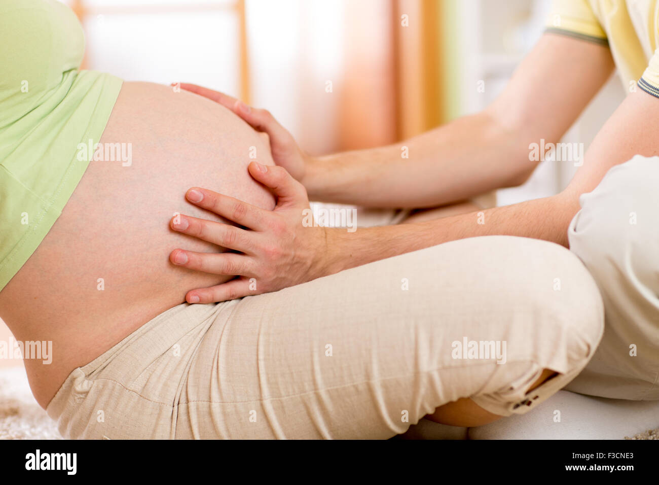 Man kommuniziert mit zukünftigen Schwiegersohn schwangere Frau Bauch zu berühren Stockfoto