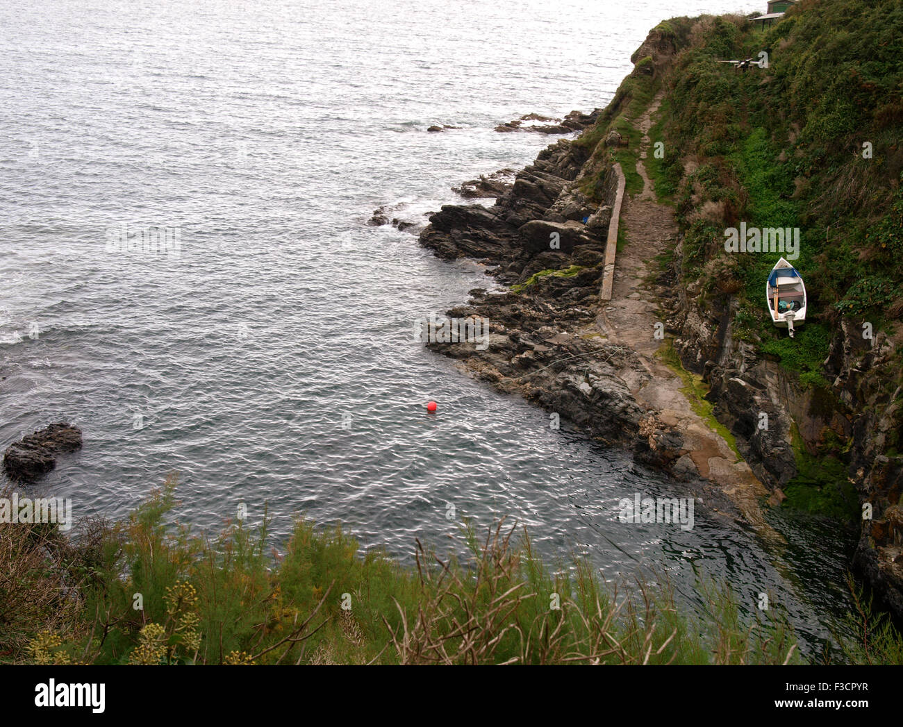 Kleines Fischerboot zog aus dem Meer mit alten manuelle Winde an der Spitze des Hügels, in der Nähe von Perranuthnoe, Cornwall, UK Stockfoto
