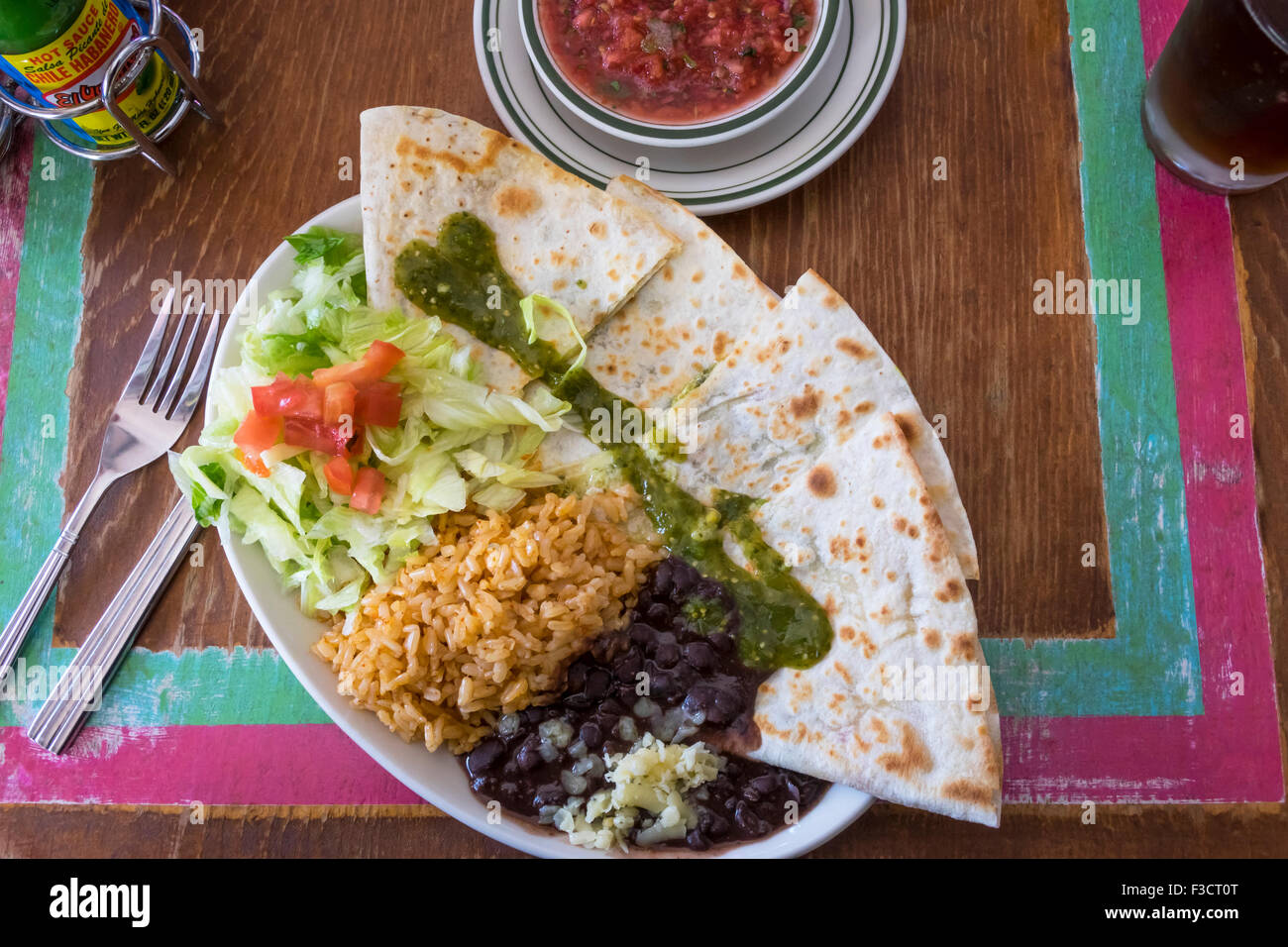 Mexikanische vegetarische Quesadillas mit schwarzen Bohnen, Reis, Salat, Salsa, dunkles Bier und scharfer sauce Stockfoto