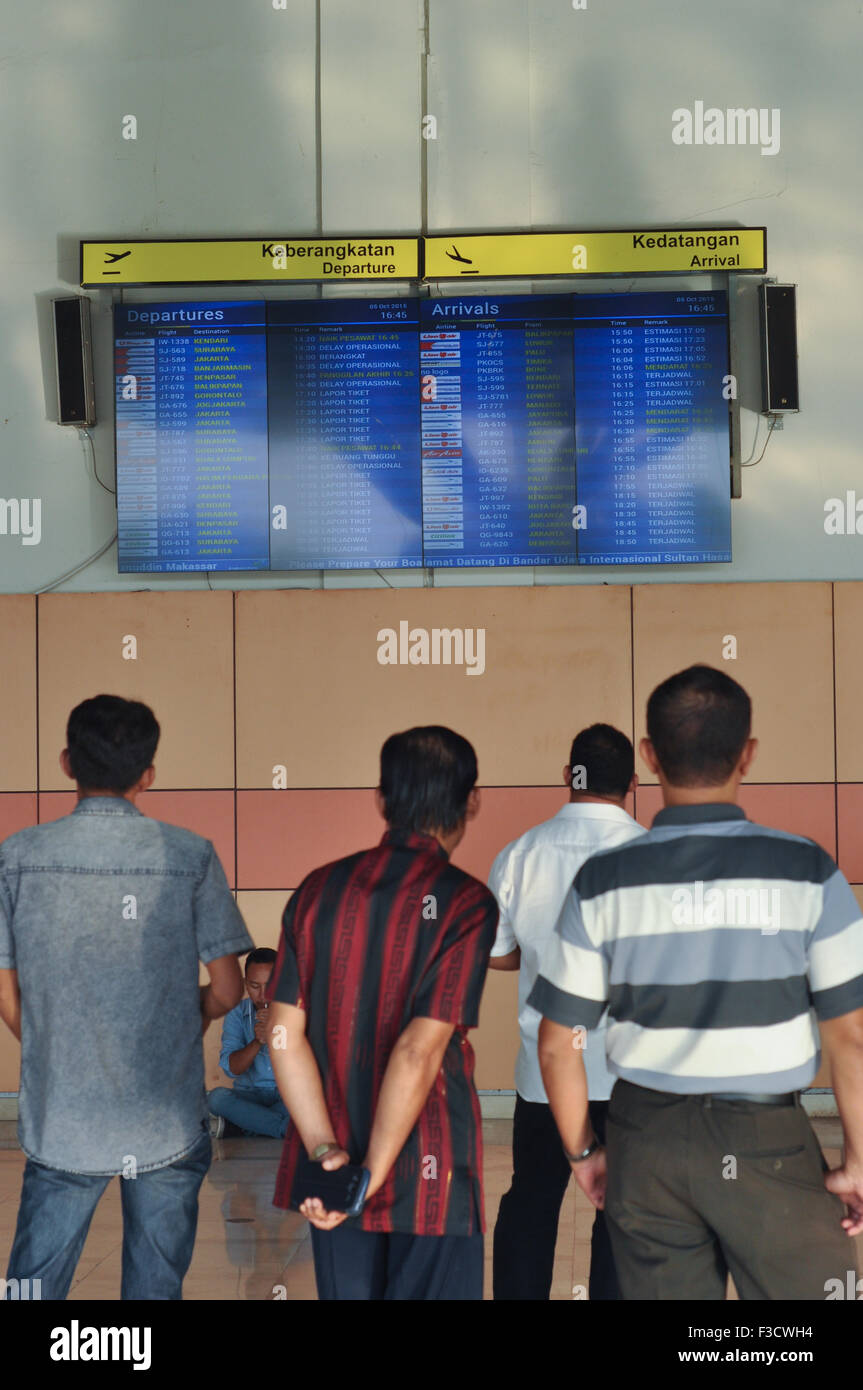 Makassar, Indonesien. 5. Oktober 2015. Passagier-Verwandten betrachten die Abfahrts- und Ankunftszeiten Zeitplan Hasanuddin International Airport in Makassar, Indonesien auf 5. Oktober 2015. Hasanuddin Flughafen zählt zu den größten Flughafen in Indonesien und das wichtigste Drehkreuz in Ostindonesien geworden. Bildnachweis: Yermia Riezky Santiago/Alamy Live-Nachrichten Stockfoto