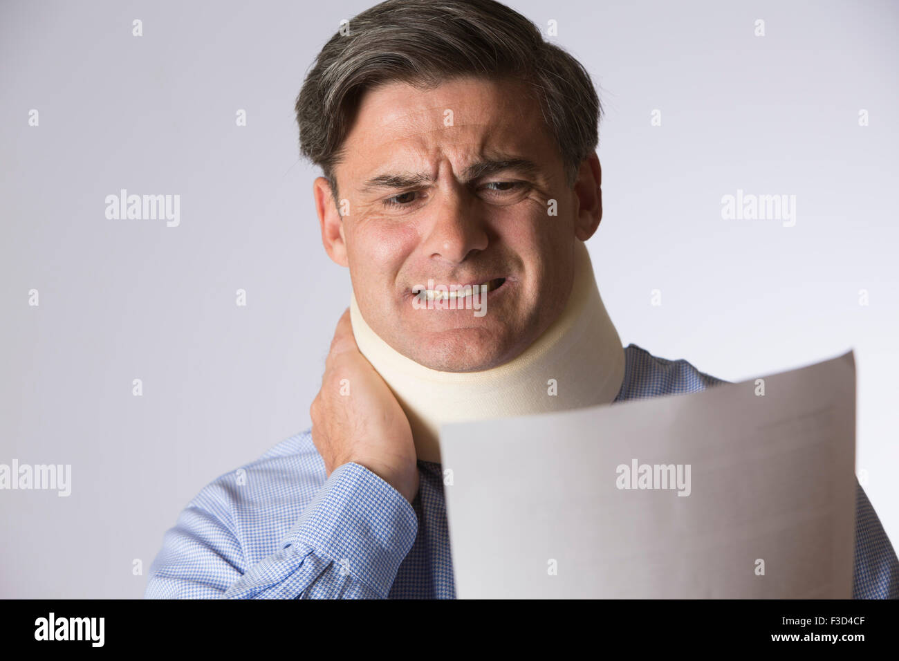 Studioaufnahme des Menschen tragen Neck Brace lesen schreiben Stockfoto