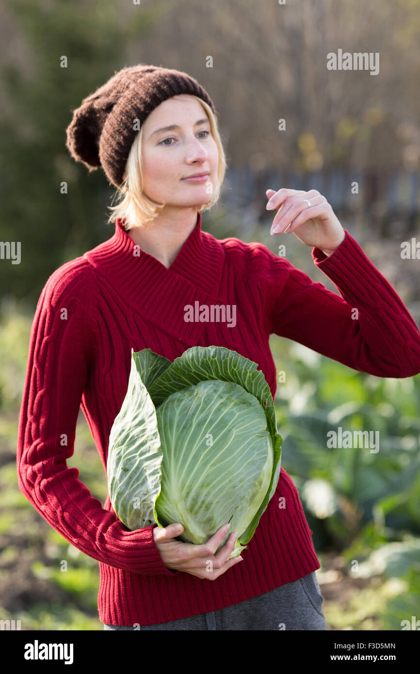 Frau hält und Inspektion frisch geerntete Kraut.  Ernte, lokale Landwirtschaft, Locavore Movenet Konzept Stockfoto