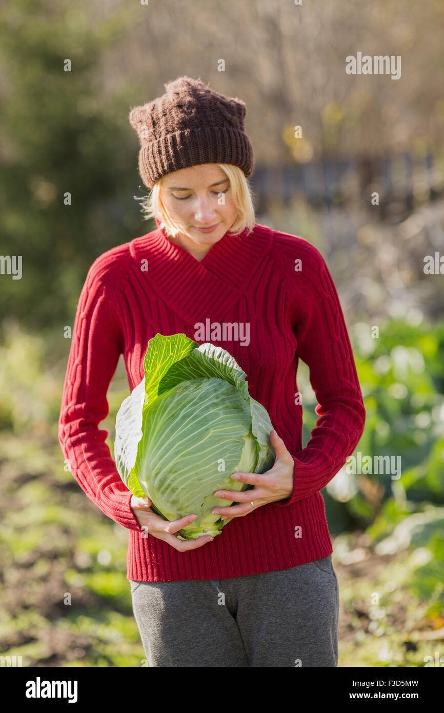 Frau hält und prüft einen frisch geerntete Kohl.  Ernte, lokale Landwirtschaft, Locavore Movenet Konzept Stockfoto