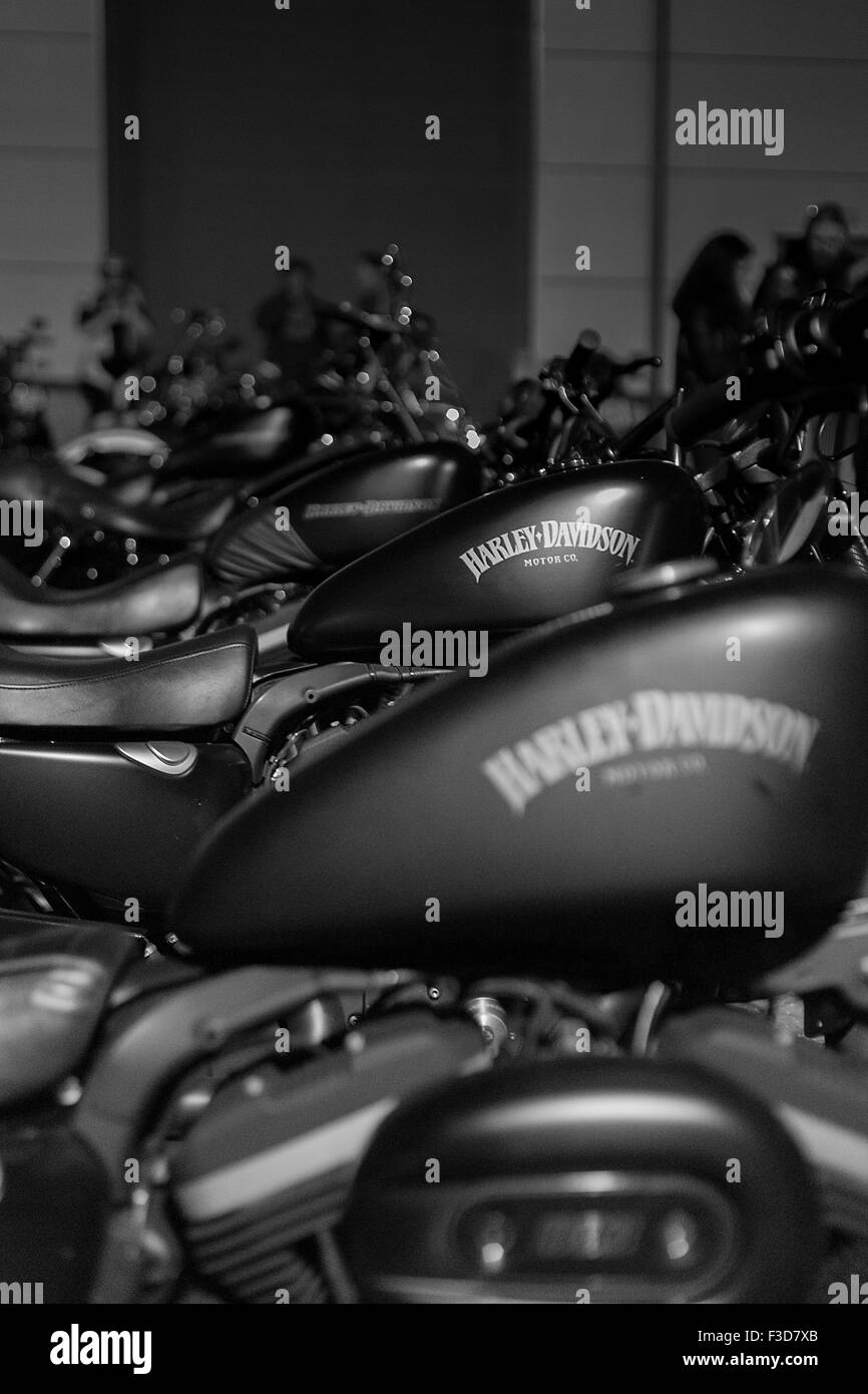 Eine Reihe von ähnlichen Harley Davidson Motorräder Linie bis auf einen dunklen Parkplatz in der Nacht. Stockfoto