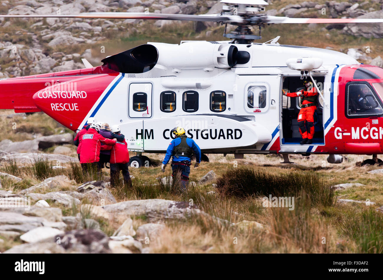 Als die Dämmerung hereinbricht, tragen Ogwen Valley Mountain Rescue Organisation Personal einen verletzten Walker an den örtlichen Rettungs-Hubschrauber Stockfoto